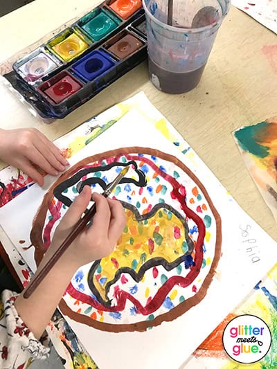 1st Grade student painting her Dot Day Book art project with tempera paints