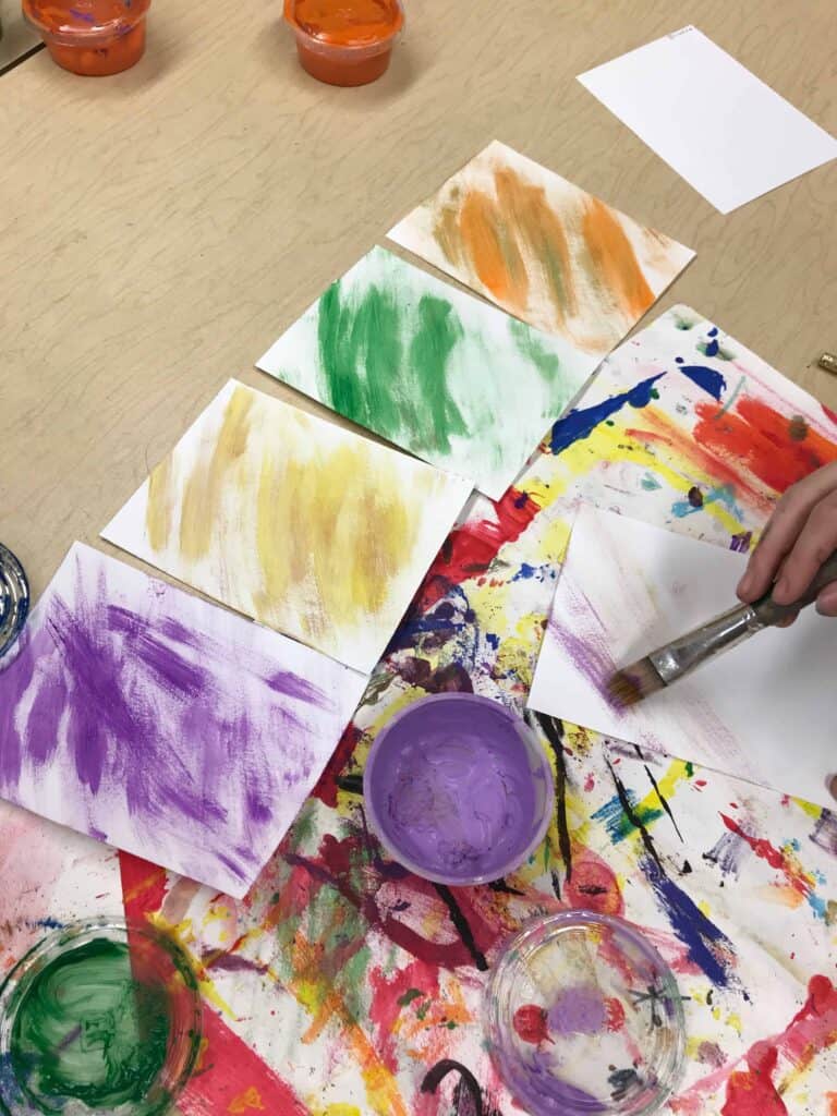Student painting paper with tempera paint.