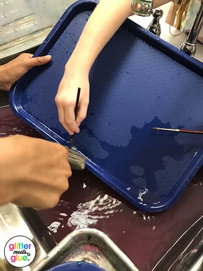 kids washing paint trays in the art room